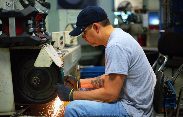 man grinding wrench down