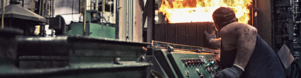 man pushing object into furnace