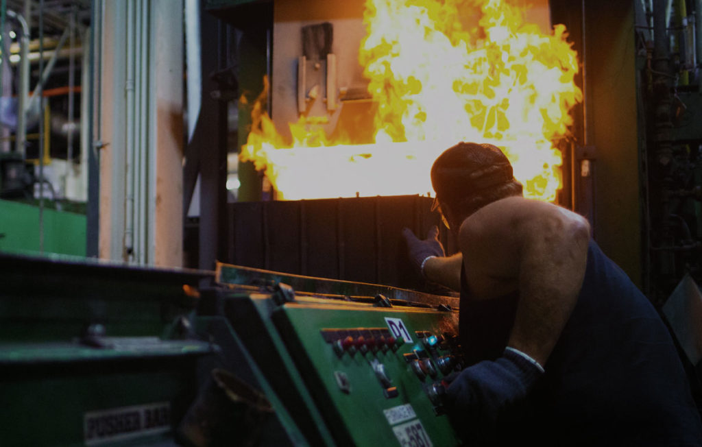 man forging metal in fire